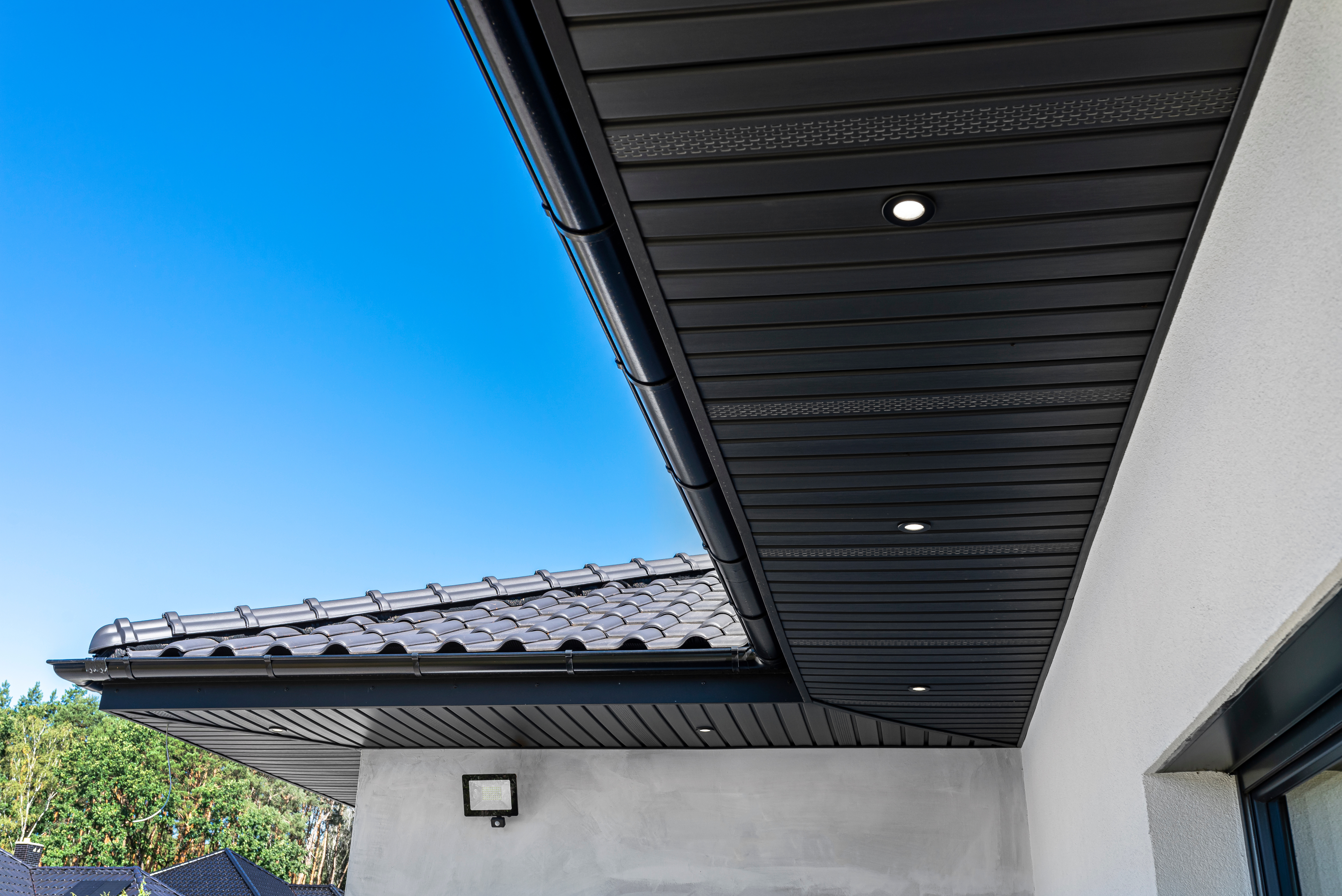 A modern graphite herringbone roof lining is attached to the trusses, visible turned on LED lights.